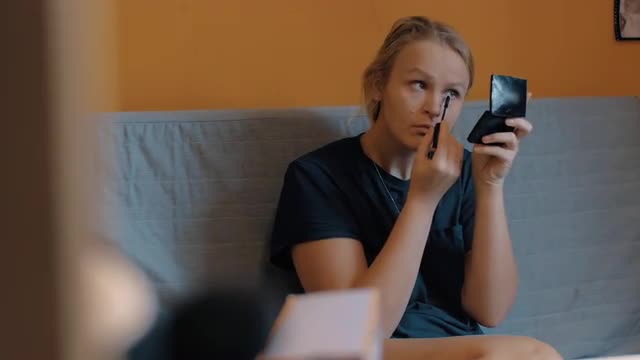 Woman putting on make-up before going out