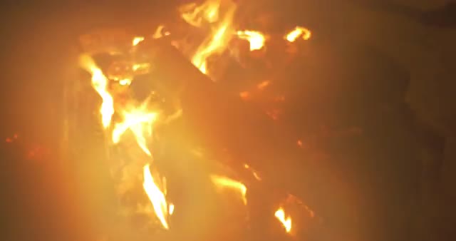 Woman putting more wood in the fire at night