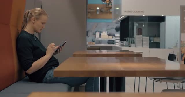 Woman in cafe browsing web on mobile