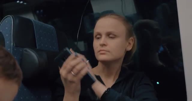 Woman commuter charging cellphone in train