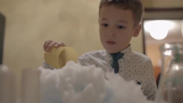 Boy watching reaction of mixing dry ice and liquid nitrogen. Fun with chemistry
