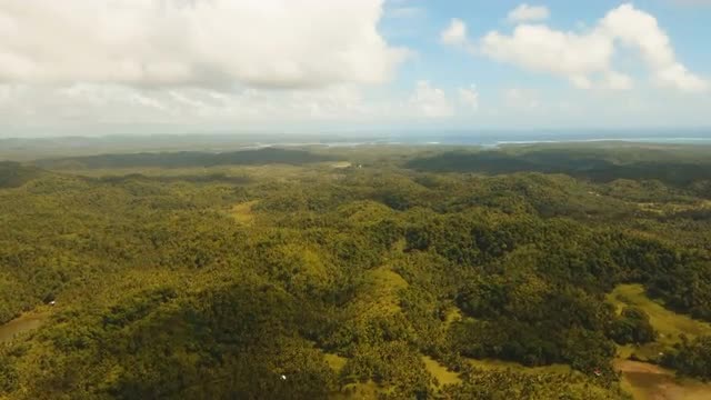 Seascape with tropical island, beach, rocks and waves. Siargao, Philippines.