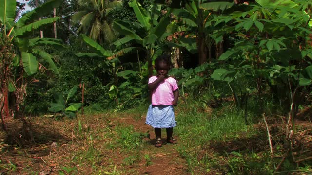 Little African girl walking up a path towards the camera.