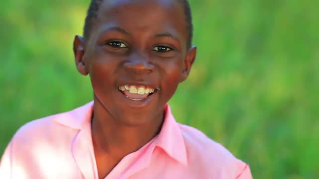 Little jumpy Kenyan boy smiling.