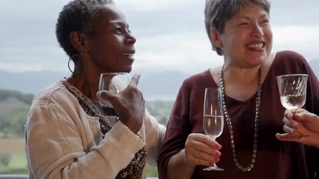 Diverse group of retired senior women in 60s laughing and talking outside