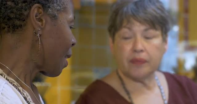 Two retired women in their 60s having a serious conversation