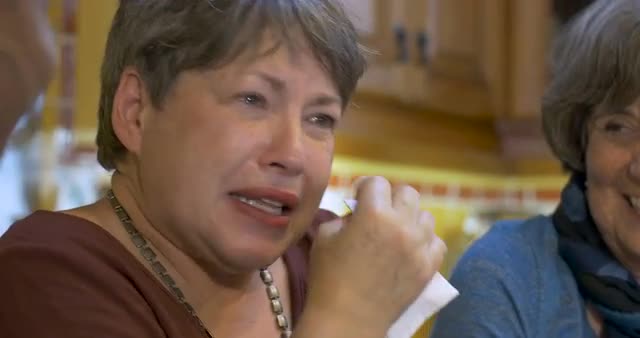 Woman wiping tears of joy with her two other friends all over 60 laughing
