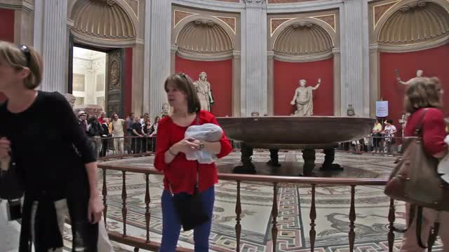 Tourists in Round Room of Vatican Museums, and around Nero's Bathtub.