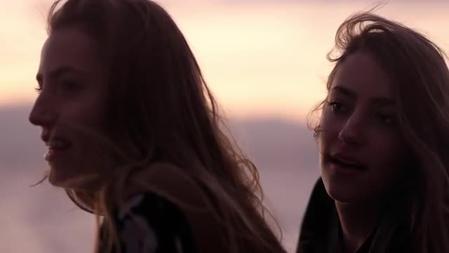 Close view of twin sisters talking at sunset
