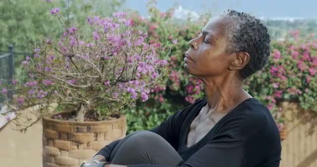 Elderly African American woman straightening her spine and stretching her neck