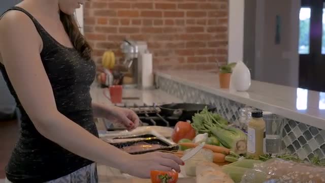 Beautiful woman making a healthy sandwich in her home kitchen