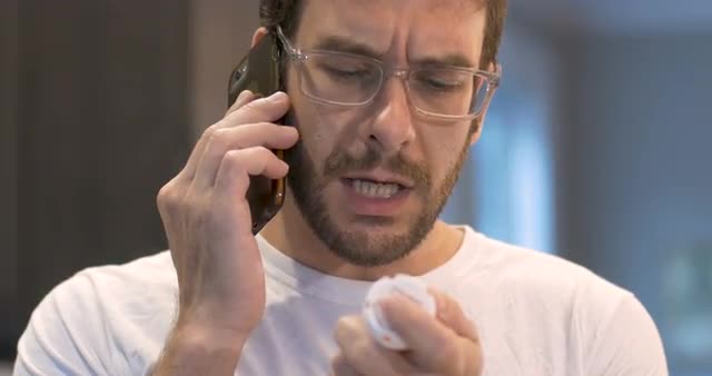 Handsome young adult man holding a pill bottle and talking on smart phone