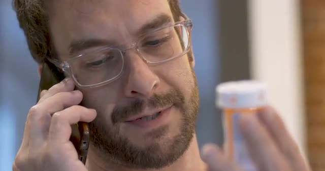 Happy young adult male refilling his prescription on his mobile phone