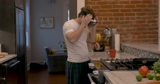 Man arriving in kitchen after waking up and putting on VR headset