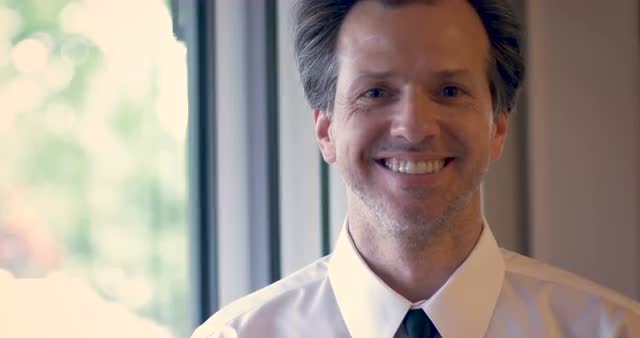 Portrait of attractive man with a shirt and tie nodding and smiling