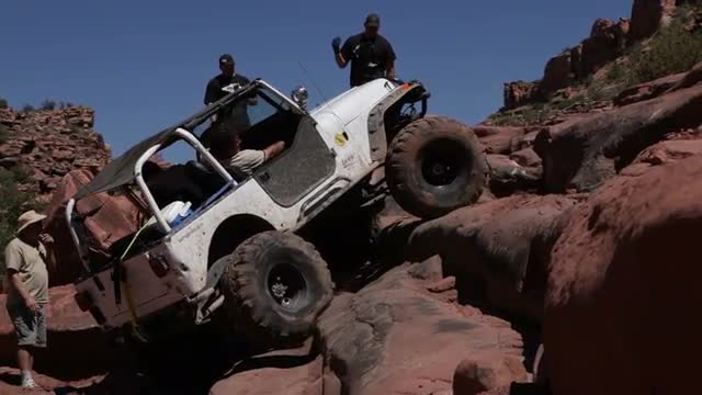 White Jeep Spins Tires and Bounces