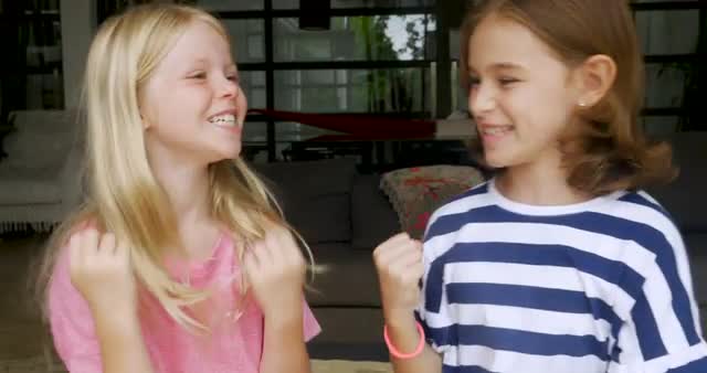 Two young girls whispering and planning something together