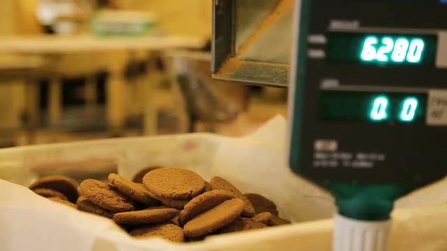 Oatmeal cookies move along the conveyor belt.