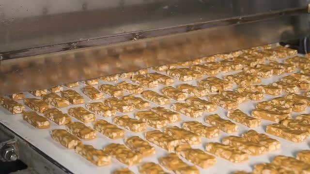 Bars of nougat with peanuts on the production line