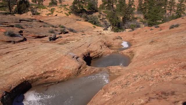 Hiking past frozen pools of water in the desert sandstone