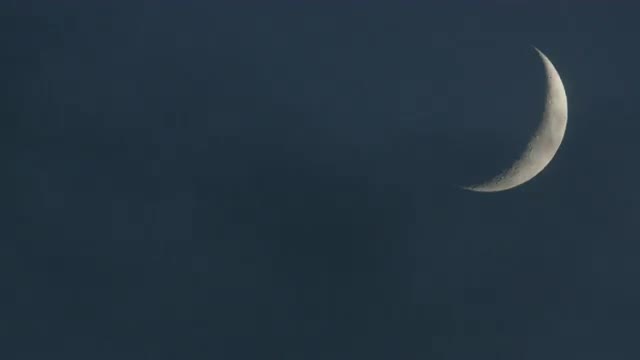 Clouds reveal crescent moon