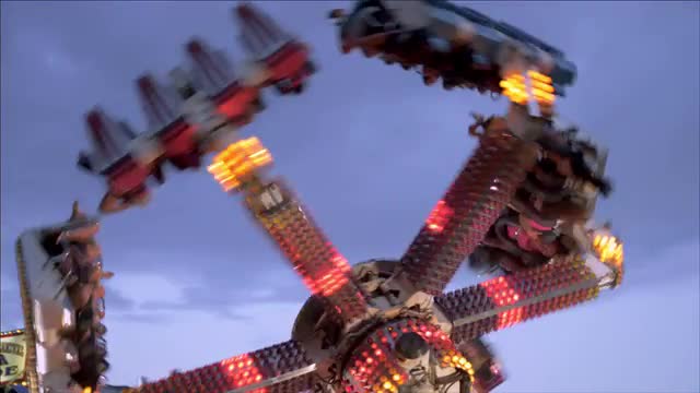 Shot of people on a carnival ride flying through the air.