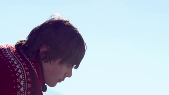Young boy in a red sweater practicing hockey outdoors.