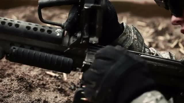 Soldier checks his machine gun