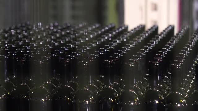 Packing of wine dark bottles in the workshop