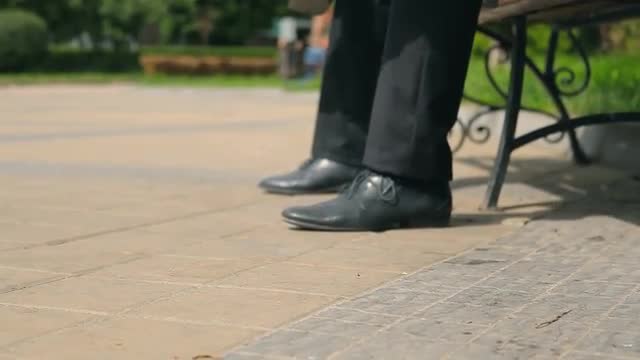 Men stand up from bench and go away