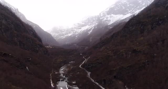Aerial shot of amazing landscape at daytime with snowy mountains and river