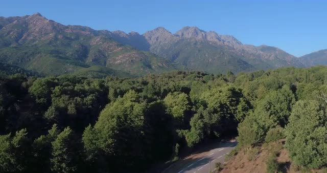 Aerial shot of the start of  Mountain range with Monte Cinto and road