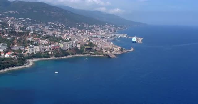 Aerial shot of Bastia cityscape on a sunny day with harbor and sea in view