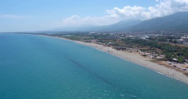 Aerial shot of Bastia cityscape on a sunny day with beach and mountains