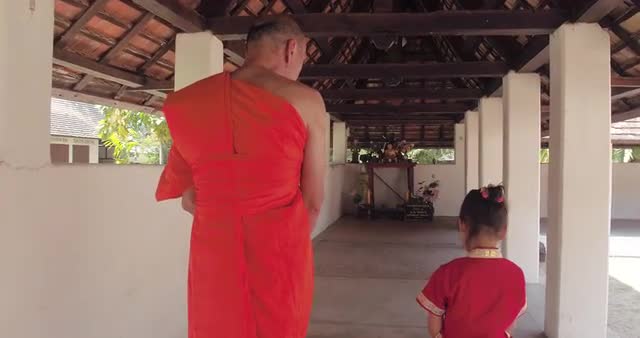 Monk and young girl in conversation inside Thai Temple ground