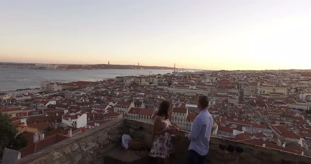 Video shot from amazing viewpoint at sunset with couple and cityscape