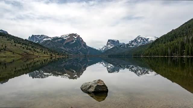 Time lapse of glassy lake viewing reflection of Square Top Mountain