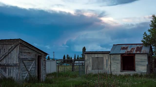 Storm clouds building in the sky over old farm sheds