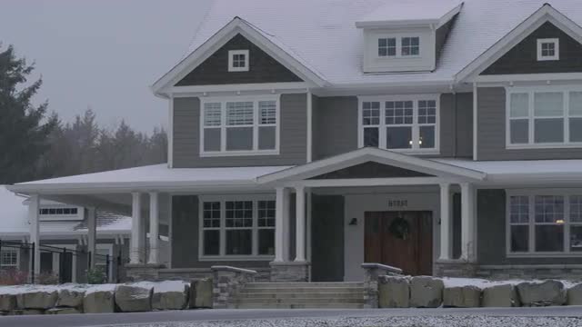 Country home in winter storm with snow falling