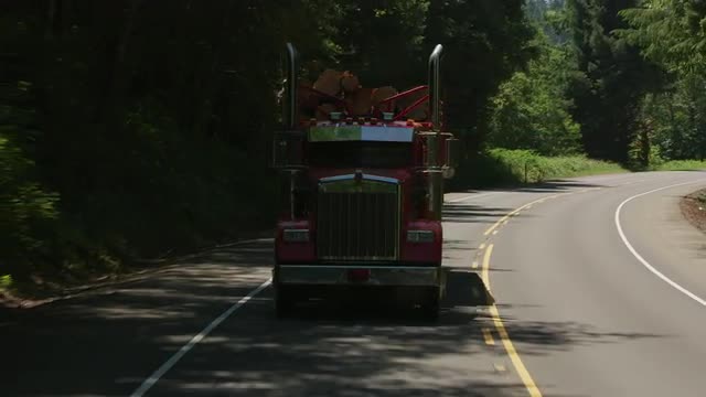 Oregon circa-2107, Logging truck driving on highway in Oregon forest.