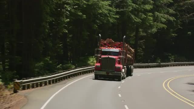 Oregon circa-2107, Logging truck driving on highway in Oregon forest.
