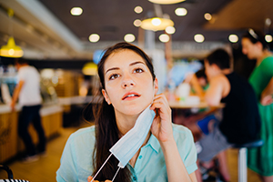 woman taking off mask