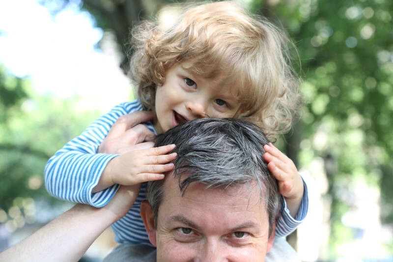 A child on top of a person's head AI-generated content may be incorrect.
