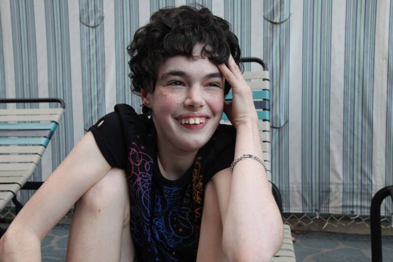 A young person sitting on a chair AI-generated content may be incorrect.