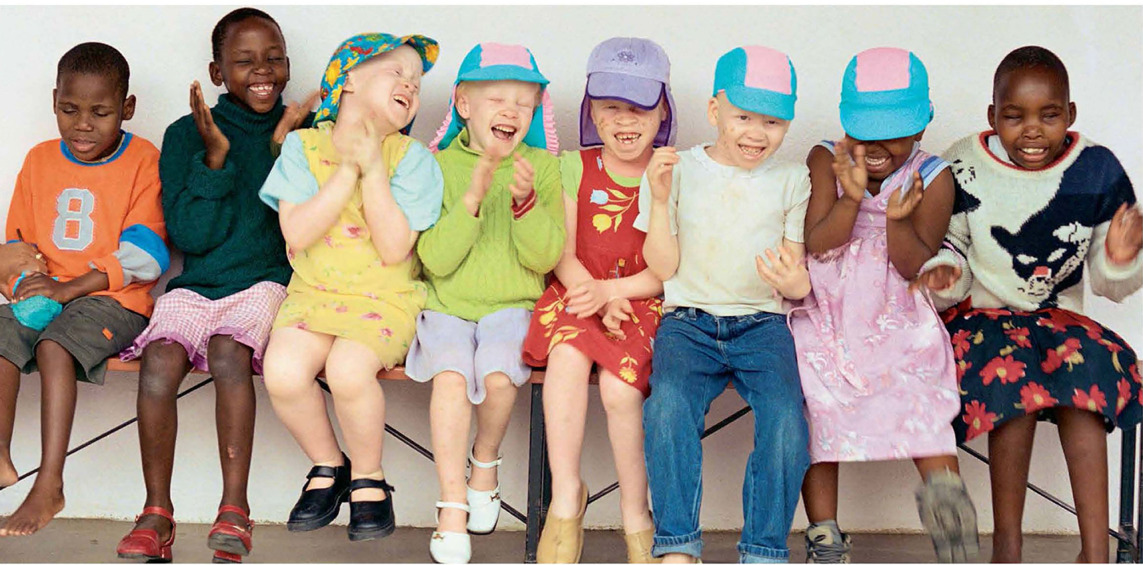 A group of children sitting on a bench AI-generated content may be incorrect.