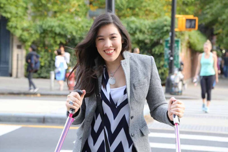 A person smiling while walking with canes AI-generated content may be incorrect.