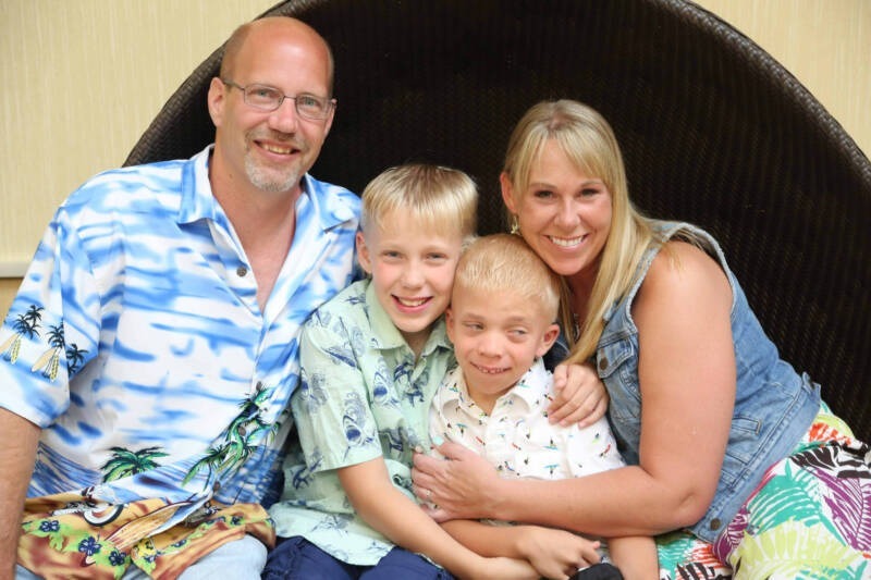 A family sitting together smiling AI-generated content may be incorrect.