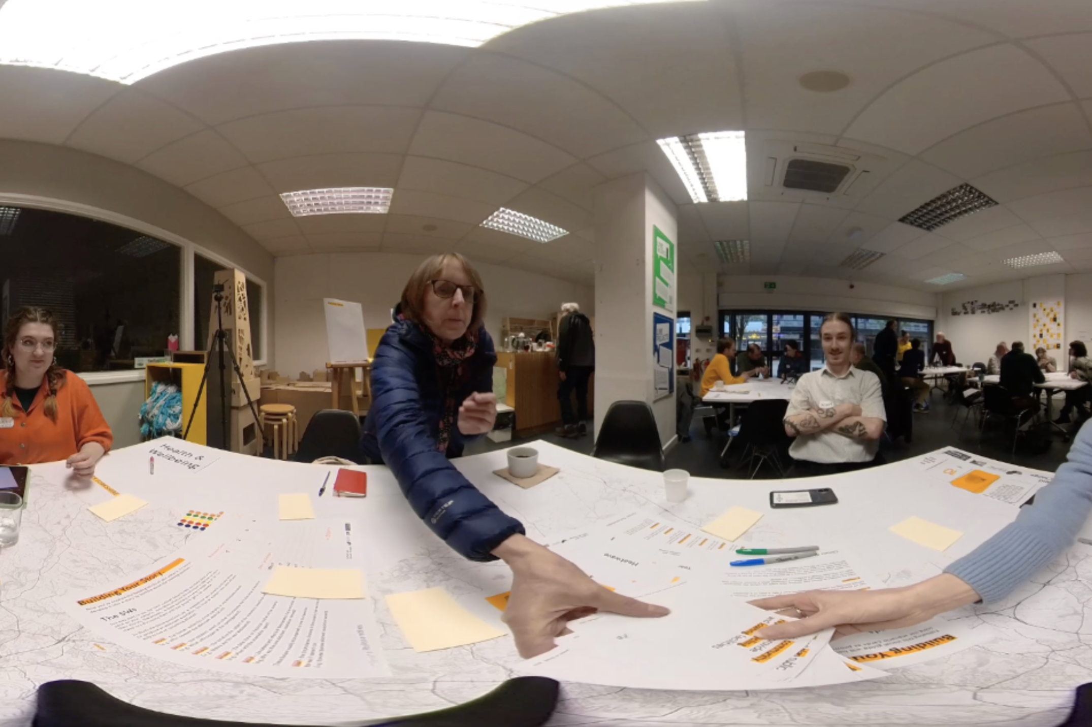 360 degree photograph showing four people sat around a table selecting scenario cards.