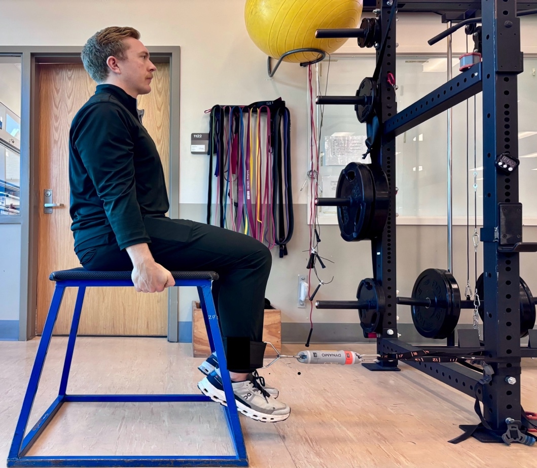 A person sitting on a blue and black bench Description automatically generated