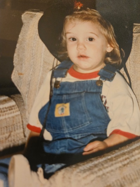 A child in a cowboy hat Description automatically generated
